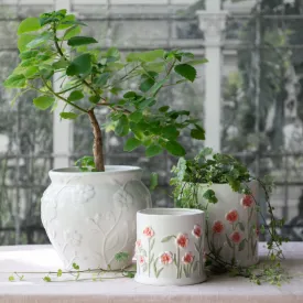 Kruka Eliza vit med reliefmönster på bord med grön växt – Wikholm Form