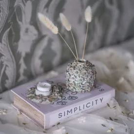 Antikgrön värmeljushållare på boklåda i ett stilleben.