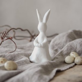 stående-vit-kanin-med-plats-för-en-kvist-fjäder-eller-blomma