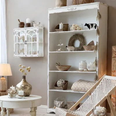 Bookcase in antique cream with a distressed patina, from Chic Antique, in a rustic, white setting.