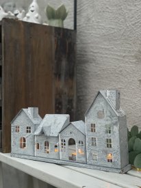 Ljuslykta husfasad No 4 i zink 785-096-00 från Affari of Sweden med fyra sammanlänkade zinkhus som lyser med värmeljus