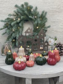 En stor samling av dekorativa keramikpumpar i hallon, rost, beige och mörkgrönt med glänsande guldstjälkar, stylade på ett grått
