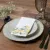 Table setting on a rustic dining table with lemon napkins and matching decor details.