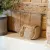 Maritime rope door holder placed at a rustic interior door on a stone floor.
