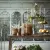 Idun Ceiling chandelier in rust-brown metal over a summery table in a greenhouse environment from Wikholm Form.