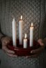 Röd adventsljusstake med tre tända ljus händerna på Ernst.