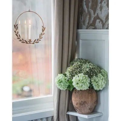 Limegrön hortensia i urna på sovrumsbord.