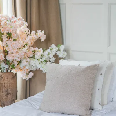 Lång körsbärsblom i vitt i en vas på nattduksbordet.