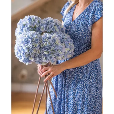 Ett fång med ljusblå hortensiakvistar i en famn.