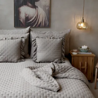 Lyxig sängbäddning i lantlig stil med ljusbrun quiltad pläd Aix utbäddad som överkast på en säng från Chic Antique