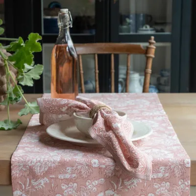 Tygservett Sonia i rosa på ett bord med löparen i samma färg från Fondaco.