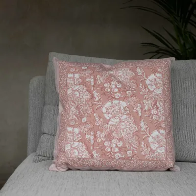 The pink cushion cover Sonia from Fondaco in a gray-beige sofa.