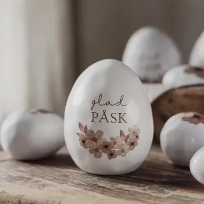 stående-vitt-ägg-med-glad-påsk-blomdekoration