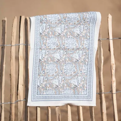 The Dante tea towel in a blue pattern from Fondaco hanging to dry on a fence.