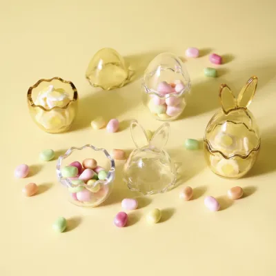 Glasburk ägg med kaninöron med godis på gult bord – Wikholm Form