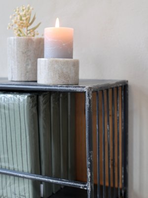 Närbild på den handmålade, slitna patinan, svetsningarna och den råa metallstrukturen på Chic Antiques antiksvarta vägghylla.
