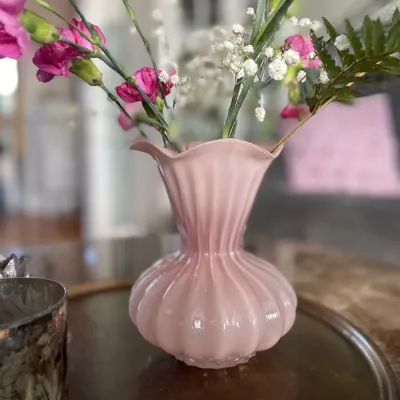 Flora rosa glasvas på bord med ceriserosa nejlikor och brudslöja från Wikholm Form