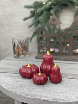 Fyra hallonröda keramikpumpar från Mitt & Ditt i storlekarna Small och Medium, vackert samlade i ett harmoniskt stilleben på ett