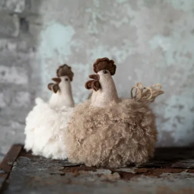 Fluffy roosters, one beige and one brown, on a table - Wikholm Form