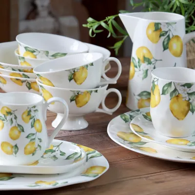 Porslinnsserien Maison Citron från Chic Antique uppdukad på ett träbord.