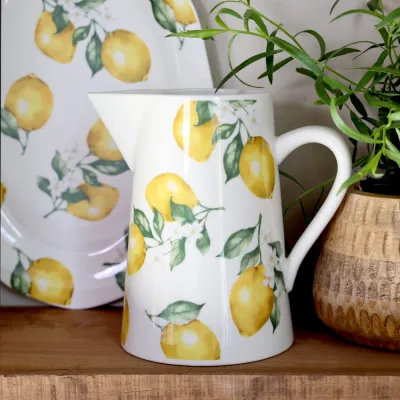 Porslinskanna Maison i cremevitt med citroner från Chic Antique på en träbänk.