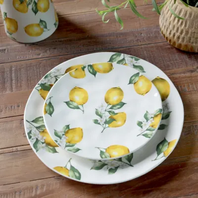 Porslinsassiett och middagstallrik i serien Maison Citron från Chic Antique på ett bord.