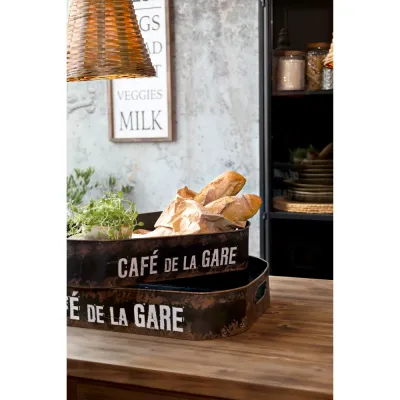 Metallbrickorna Café De La Gare med kryddväxt och bröd.