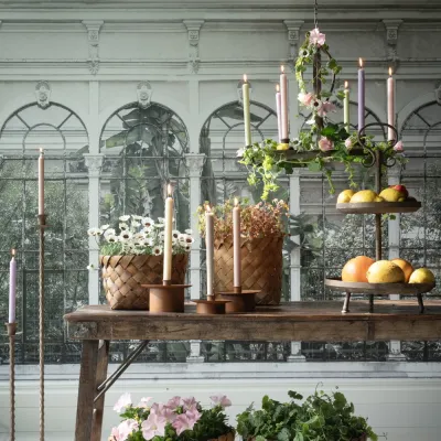 Idun Ceiling chandelier in rust-brown metal over a summery table in a greenhouse environment from Wikholm Form.