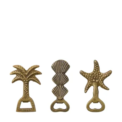 Three Ayra bottle openers in antique gold depicting a palm tree, shells and a starfish from Wikholm Form.