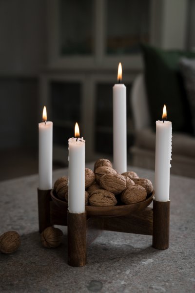 Adventsljusstake i mörkt trä på ett bord med duk och fyra tända ljus från Ernst.